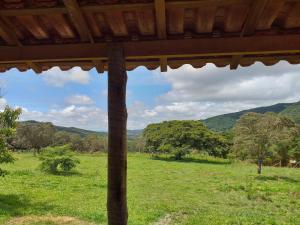 a view of a field with mountains in the background at camping toca raul in São Thomé das Letras