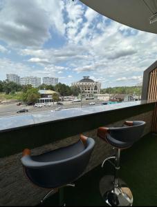 een balkon met een stoel en uitzicht op een stadion bij Luxury City-Centric Apartment for Booking in Chişinău