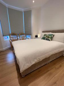 a bedroom with a large bed and two chairs at Liverpool Cherry House - 4 Bedrooms in Liverpool