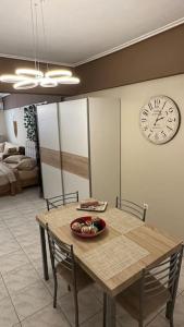 comedor con mesa y reloj en la pared en Central Modern Apartment Volos ll, en Volos