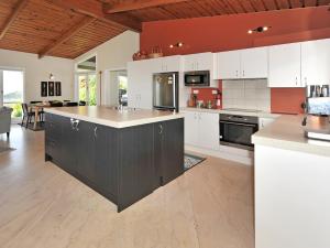 a kitchen with white cabinets and an island in it at Kereru at Kaiteriteri - Kaiteriteri Holiday Home in Kaiteriteri
