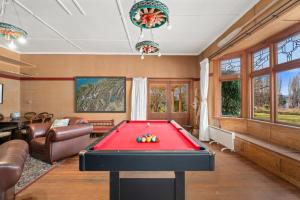 - un salon avec une table de billard rouge dans l'établissement Glendhu Station Homestead - Glendhu Bay Home, à Glendhu