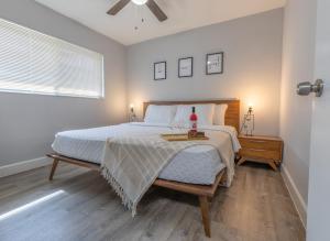 a white bedroom with a bed and a window at AirportHouse in Dania Beach