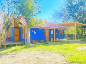 a blue and orange house with a porch at Cabaña de Campo tulahuen in Piedra Lisa