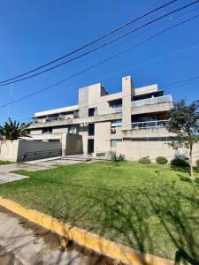 un gran edificio blanco con un patio delante en Monoambiente en Yerba Buena en Yerba Buena