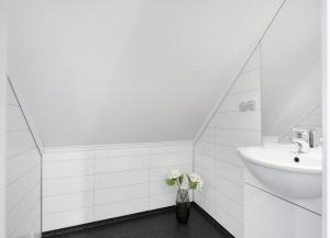 a bathroom with a sink and a vase of flowers at 5-Bedroom Apartment in Åsane, Bergen in Bergen