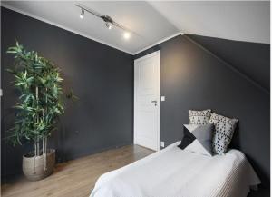 a bedroom with a bed and a black wall at 5-Bedroom Apartment in Åsane, Bergen in Bergen
