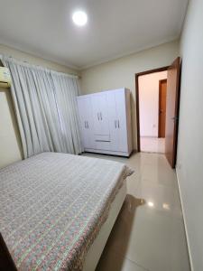 1 dormitorio con 1 cama y armarios blancos en Casa na Lagoa, en Maricá