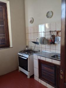 a small kitchen with a stove and a sink at Casa rústica 2 em Santa Teresa in Rio de Janeiro