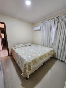 a bedroom with a bed and a window at Casa na Lagoa in Maricá