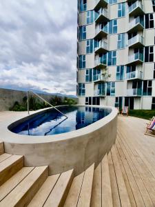 a building with a swimming pool in front of a building at Cozy & Modern - Near the Airport in San José