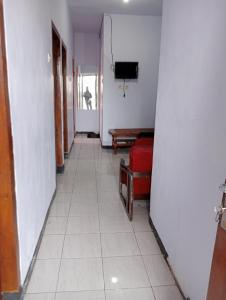 a hallway with a room with a television and a tiled floor at Mentigen Homestay in Ngadisari