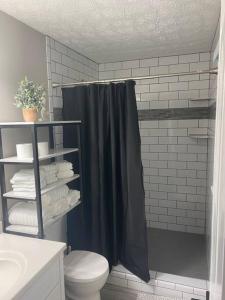 La salle de bains est pourvue d'un rideau de douche noir et de toilettes. dans l'établissement Ranch - Allatoona Lake, LakePoint Sporting, Hiking, à Acworth