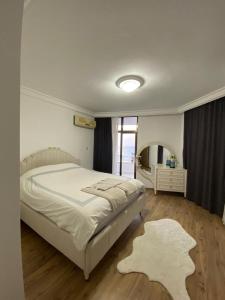een slaapkamer met een groot bed en een groot raam bij Luxury apartment with sea view in Mezitli