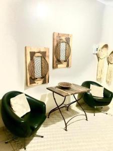 two green chairs and a table in a room at Leather and Lace & a Suitcase in Groutfontein