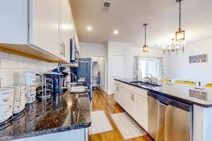 a kitchen with white cabinets and black counter tops at Daisy Place in Charleston