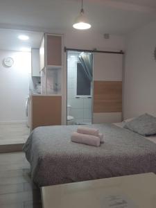 サン・ファン・デ・アスナルファラチェにあるEL RINCON DE SEVILLA a 9 min. del centro en Metroのベッドとタオル2枚のある寝室