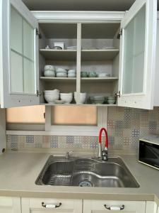 eine Küche mit Spüle und weißen Schränken in der Unterkunft Hongdae, Private Flats in Seoul + 42 Fotos