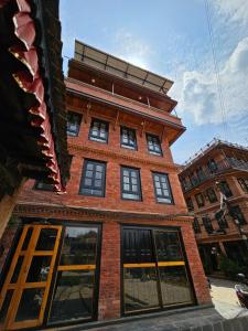 a brick building with windows on a street at Hotel Durbar Side in Bhaktapur
