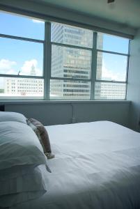 a bedroom with a white bed with a view of a city at Entire High-Rise Apartment - 2BD in Baton Rouge