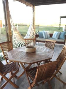 a wooden table and chairs on a porch with a hammock at La Toscana 1 in Piriápolis