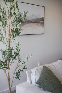 un árbol en una sala de estar junto a un sofá en Entire High-Rise Apartment - 2BD en Baton Rouge