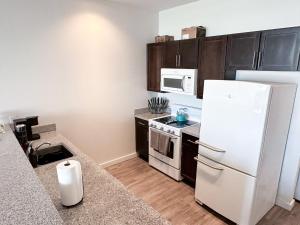 a kitchen with a white refrigerator and a microwave at Entire High-Rise Apartment - 2BD in Baton Rouge