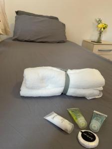 a white towel with a tie on a bed at Stratford Guest House By Cosystays in London