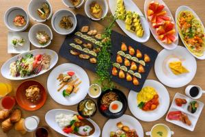 een tafel gevuld met borden met voedsel en kommen met voedsel bij Hotel Forza Oita in Oita