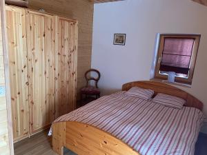 1 dormitorio con cama de madera y ventana en Apartment The Amethyst en Evolène