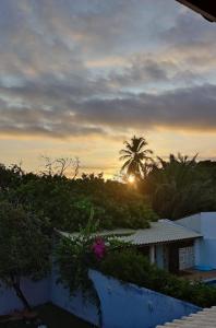 a view of the sunset from the balcony of a house at Suite Fogo - A Casa 9 Lilás em Barra de Jacuipe in Camaçari