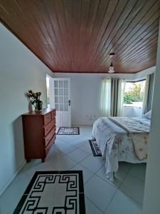 1 dormitorio con cama y techo de madera en Suite Fogo - A Casa 9 Lilás em Barra de Jacuipe, en Camaçari