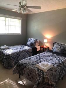 a bedroom with two beds and a ceiling fan at Quiet Kennesaw 3BR home - close to KSU, Lakepoint in Kennesaw