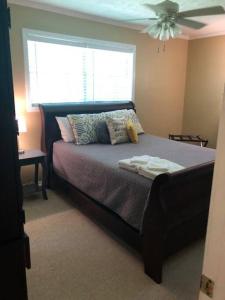a bedroom with a bed with a ceiling fan at Quiet Kennesaw 3BR home - close to KSU, Lakepoint in Kennesaw