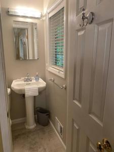a white bathroom with a sink and a mirror at Quiet Kennesaw 3BR home - close to KSU, Lakepoint in Kennesaw