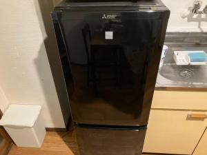 a black refrigerator in a kitchen next to a sink at Nishimoto Building - Vacation STAY 34362v in Hiroshima