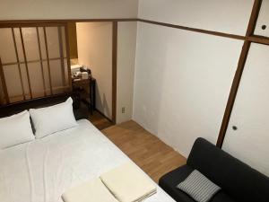 a small room with a bed and a chair at Nishimoto Building - Vacation STAY 34362v in Hiroshima