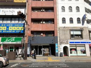 a person walking on a city street with buildings at Nishimoto Building - Vacation STAY 34362v in Hiroshima