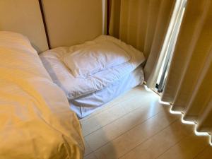 uma cama não feita sentada num canto de um quarto em Nishimoto Building - Vacation STAY 16015v em Hiroshima