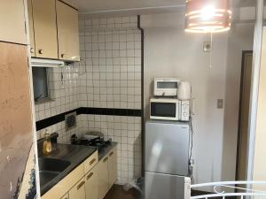 a small kitchen with a refrigerator and a microwave at Nishimoto Building - Vacation STAY 16010v in Hiroshima