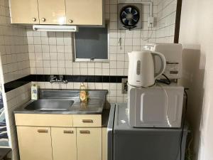 a small kitchen with a sink and a refrigerator at Nishimoto Building - Vacation STAY 16010v in Hiroshima