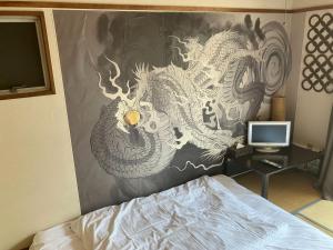 a bedroom with a painting of a dragon on the wall at Nishimoto Building - Vacation STAY 16012v in Hiroshima