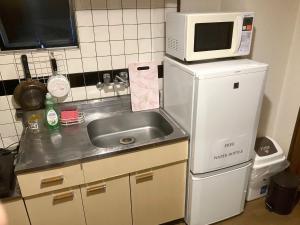a small kitchen with a sink and a microwave at Nishimoto Building - Vacation STAY 16012v in Hiroshima