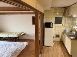 Habitación con cocina con fregadero y nevera. en Nishimoto Building - Vacation STAY 93789v, en Hiroshima