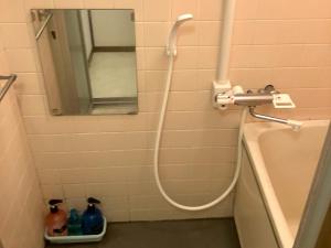 a shower with a hose in a bathroom at Nishimoto Building - Vacation STAY 93789v in Hiroshima