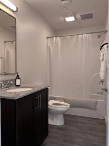 y baño con aseo, lavabo y ducha. en Stylish Downtown High-Rise - 2BD en Baton Rouge