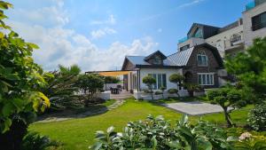 a house with a lawn in front of it at Someday Jeju in Jeju