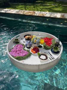 a circular table in the water with food and drinks at Villa Gekyu in Jimbaran