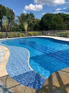 una piscina de agua azul y una valla en HOTEL EL RUBY, en San Martín