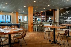 a restaurant with tables and chairs and a bar at Delta Hotels by Marriott Daytona Beach Oceanfront in Daytona Beach